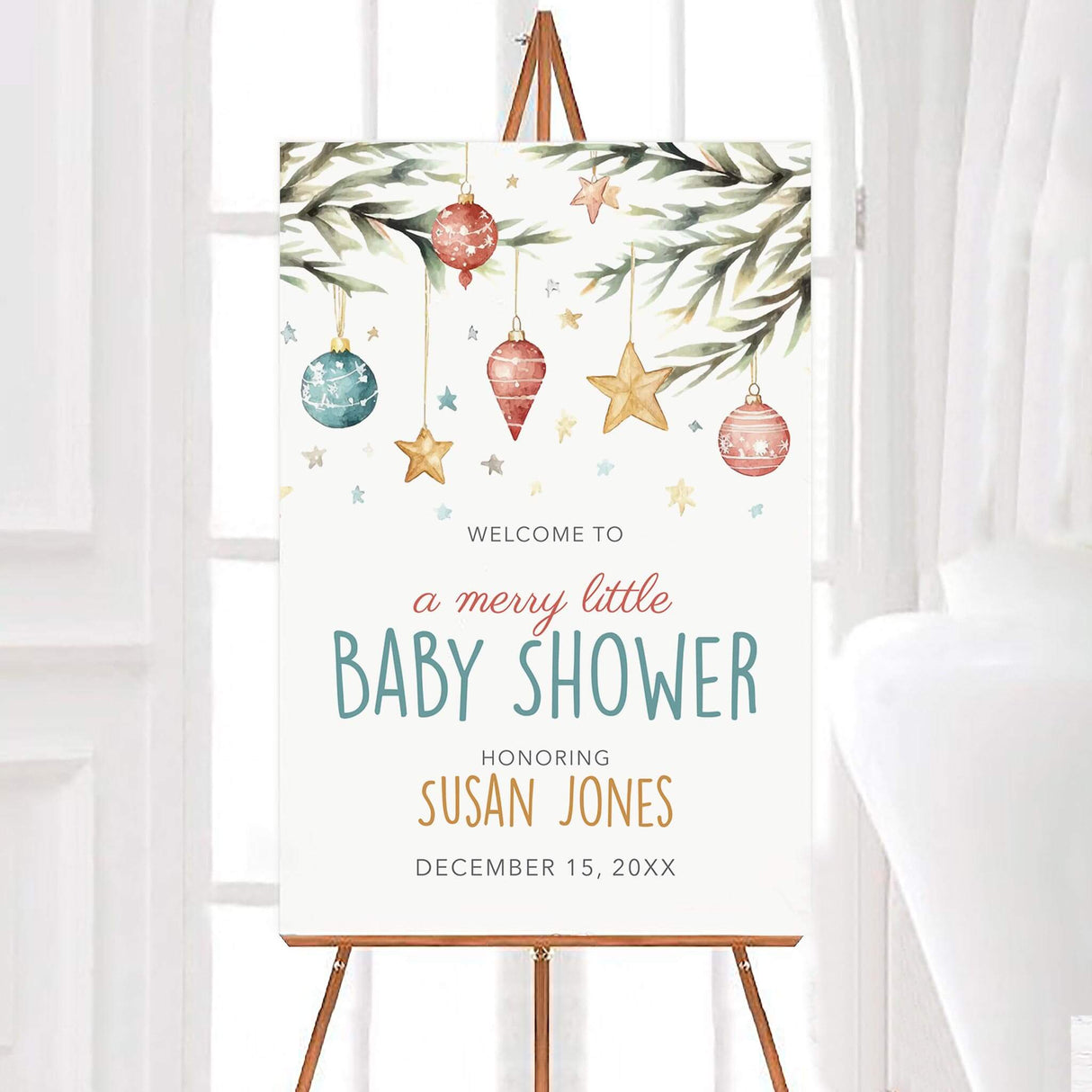 Christmas baby shower invitation with ornaments, stars, and pine branches, featuring text 'A Merry Little Baby Shower' on an easel display.