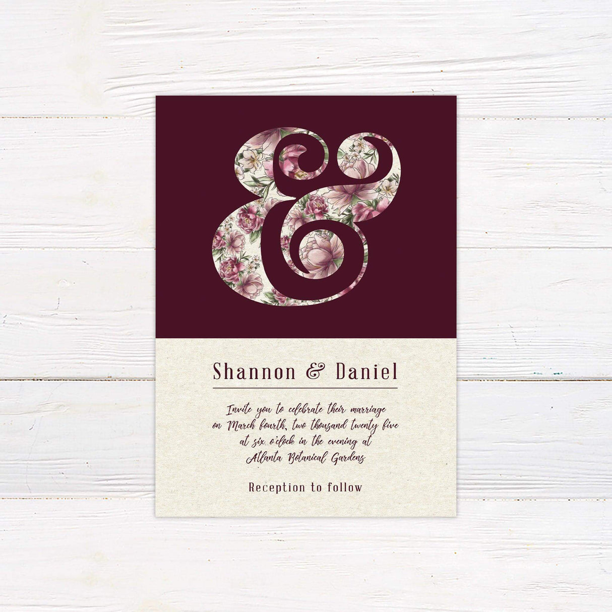 Wedding invitation with floral ampersand on burgundy background, cream base, and romantic script—perfect for garden or vintage-themed weddings.