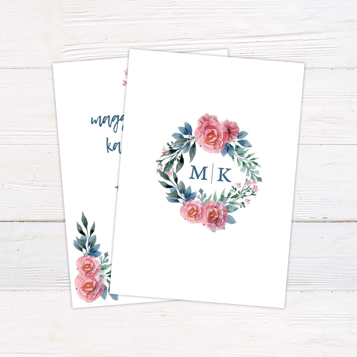 April wedding invitation with pink roses, greenery, and blue handwritten script on a white background – ideal for spring or garden-themed weddings. back
