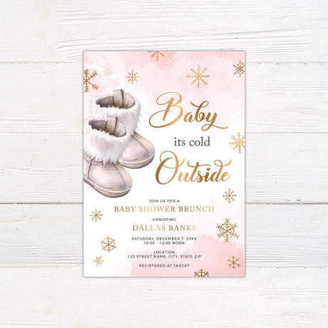 Baby It's Cold Outside pink baby shower invitation featuring snowflakes and baby boots on a rustic wooden background.