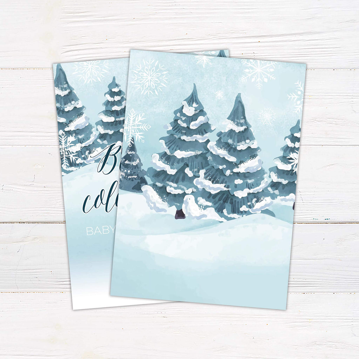 Winter-themed baby shower invitation with snowy trees for 'Baby It's Cold Outside' event.
