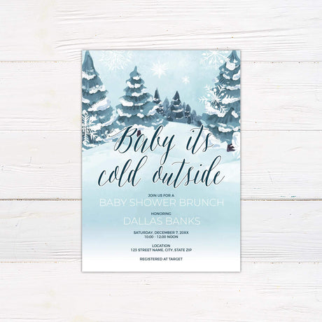 Baby It's Cold Outside winter-themed baby shower invitation with snow-covered trees, RSVP details, and event location.