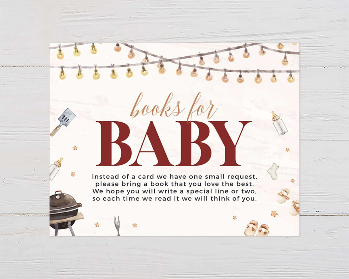 Baby shower invitation with "Books for Baby" theme, string lights, barbecue grill, and baby items on white wood background.