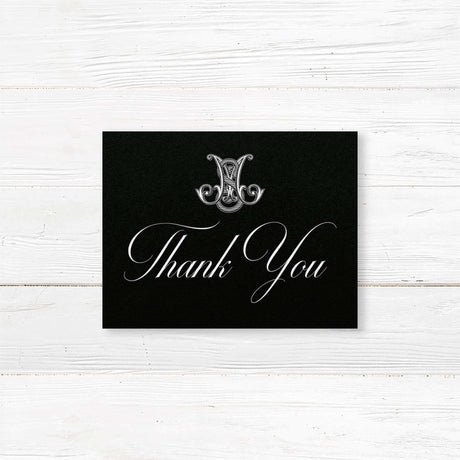 Black Celtic Monogram Wedding Invitation - Black Celtic monogram thank you card with script fonts on white wood background.
