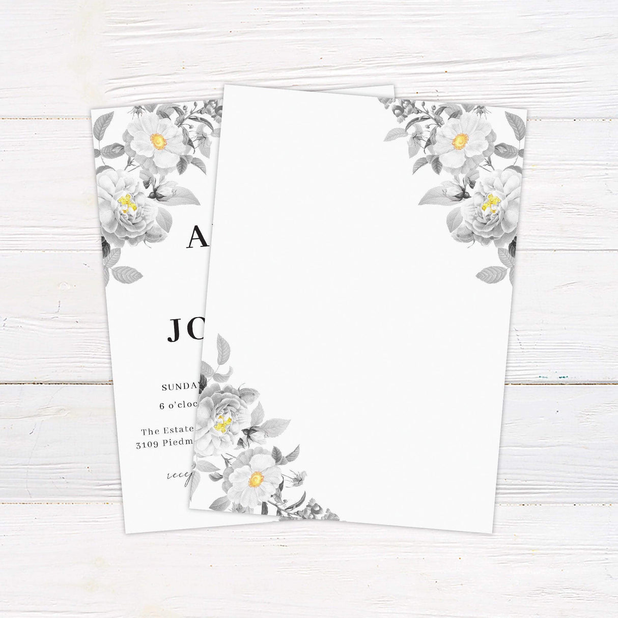 Botanical wedding invitation with black and white floral illustrations and soft yellow centers, modern serif and script fonts on a light background. back
