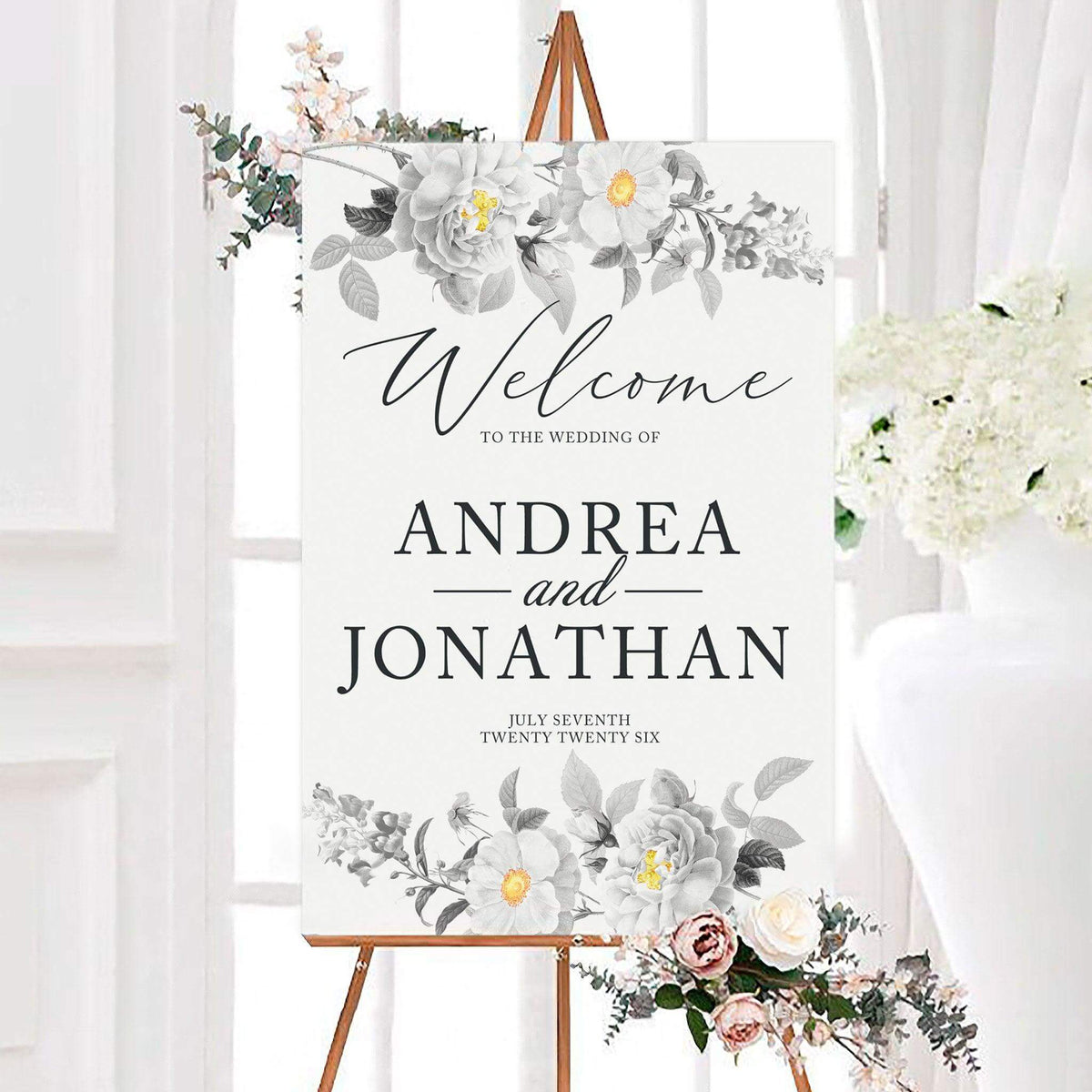 Vintage black and yellow botanical wedding welcome sign featuring detailed floral arrangements with subtle golden accents. Personalized names and a wedding date are displayed in elegant script and classic serif lettering.