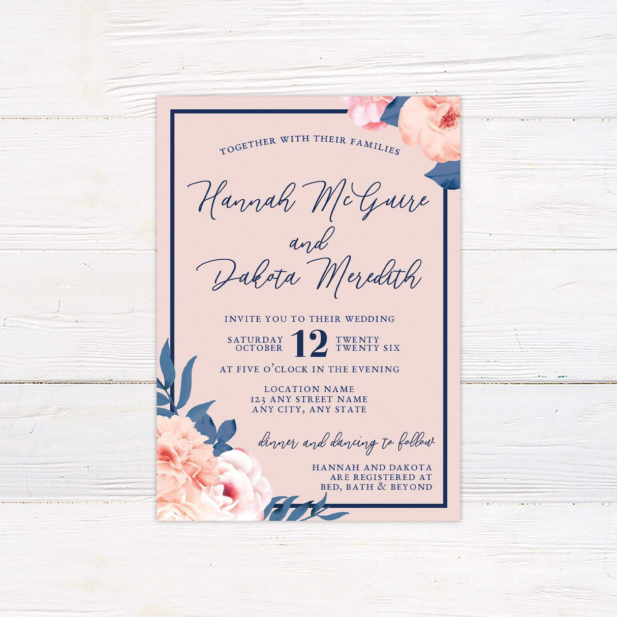 Pink wedding invitation with navy blue border and script text, decorated with blush and coral peonies.