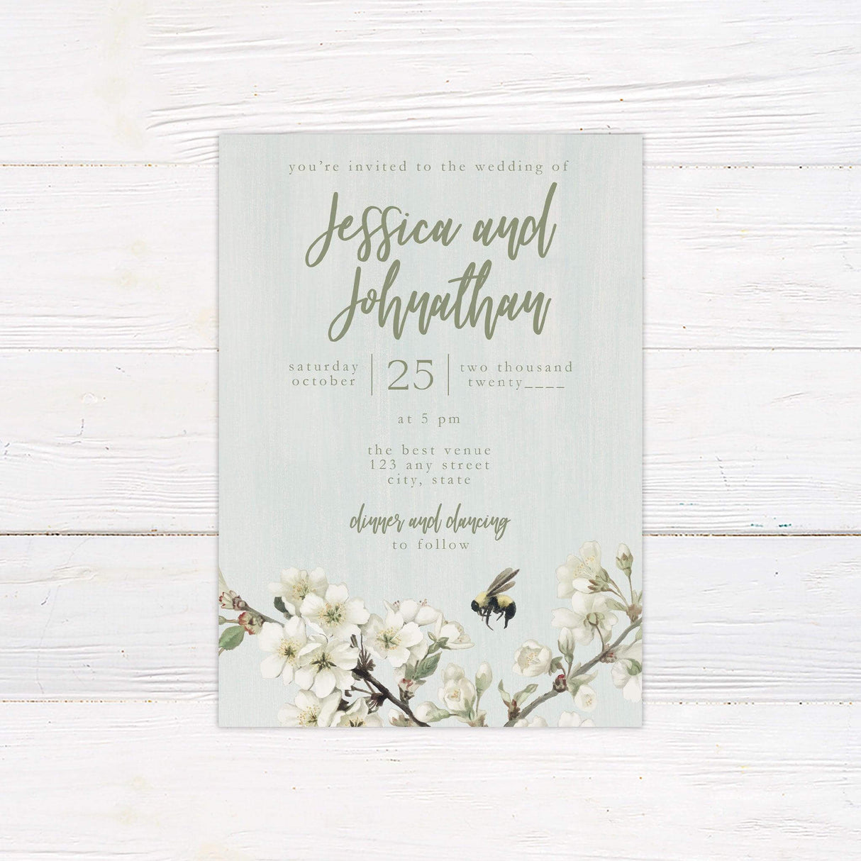 Spring wedding invitation with green background, white blossoms, a watercolor bumblebee, and elegant script—perfect for garden or nature-themed weddings.