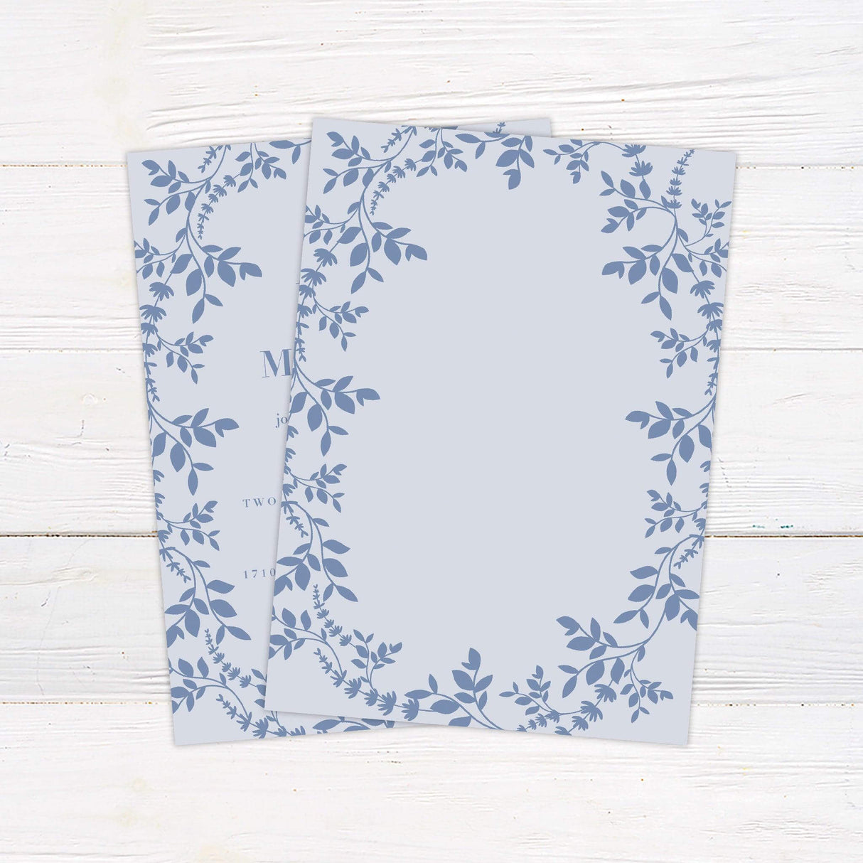 Light blue wedding invitation with botanical floral border, elegant serif fonts, and garden-inspired layout for spring or summer ceremonies. back