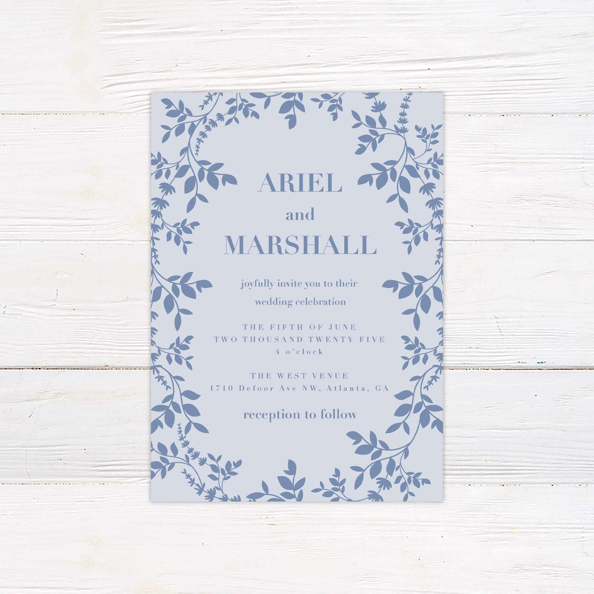 Light blue wedding invitation with botanical floral border, elegant serif fonts, and garden-inspired layout for spring or summer ceremonies.