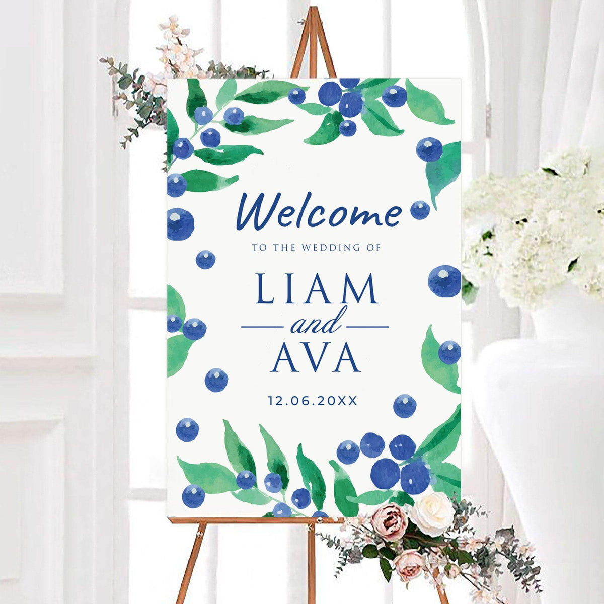 Watercolor blue berry wedding welcome sign featuring blue berries, green leaves, personalized names, and a wedding date. Botanical branches frame the design against a clean white background.