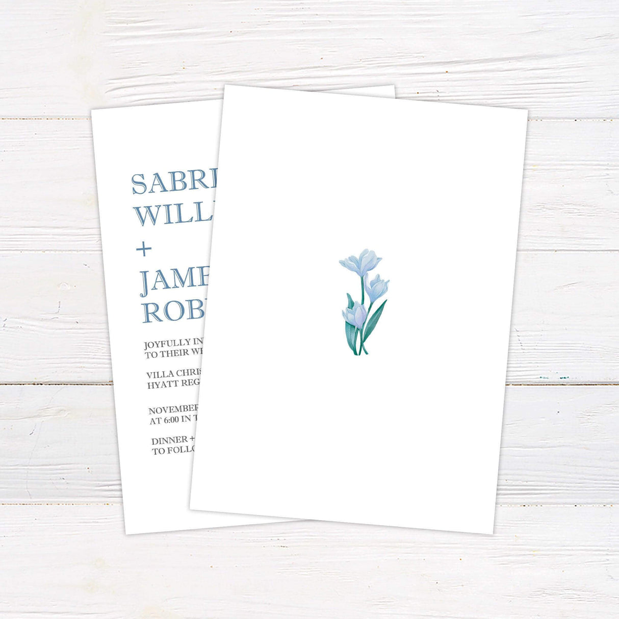 Minimalist wedding invitation with modern serif fonts, soft blue watercolor lilies, and clean layout for elegant evening or garden weddings. back
