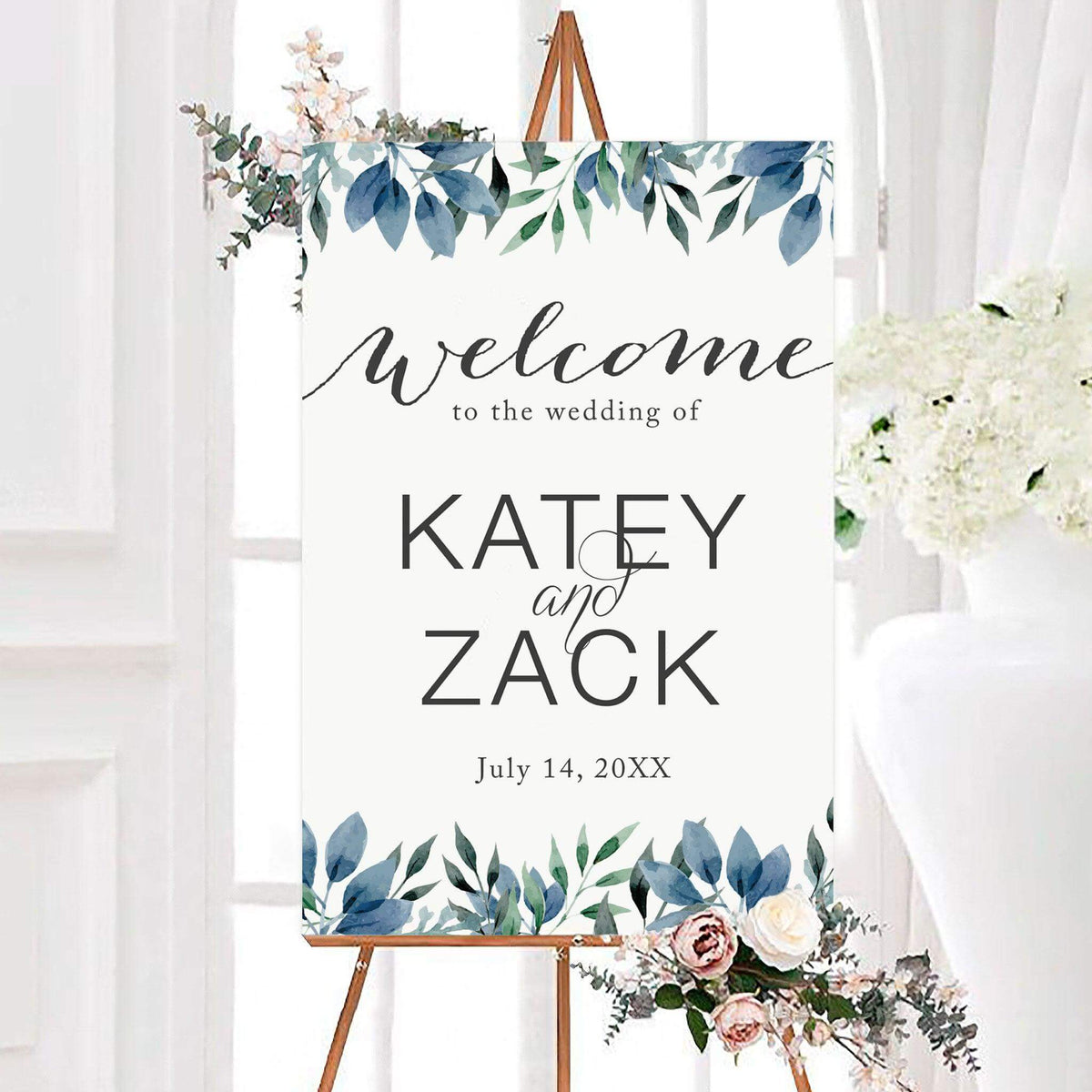 Personalized watercolor leaves wedding welcome sign featuring blue watercolor leaves, soft green botanical foliage, and elegant script and modern lettering. The botanical wedding entrance sign includes customizable couple's names and wedding date framed by delicate leafy branches.
