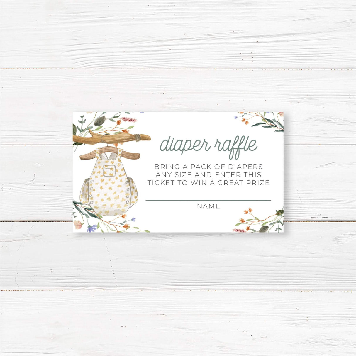 Printed baby shower diaper raffle ticket featuring a boho-style baby romper hanging on a rustic wooden hanger with delicate floral accents. These pre-printed raffle cards encourage guests to bring a pack of diapers for a chance to win a prize, making them a fun and practical game for a baby shower. Printed on high-quality cardstock, pre-cut, and ready to use. Perfect for a boho, rustic, or woodland baby sprinkle or gender-neutral baby shower.