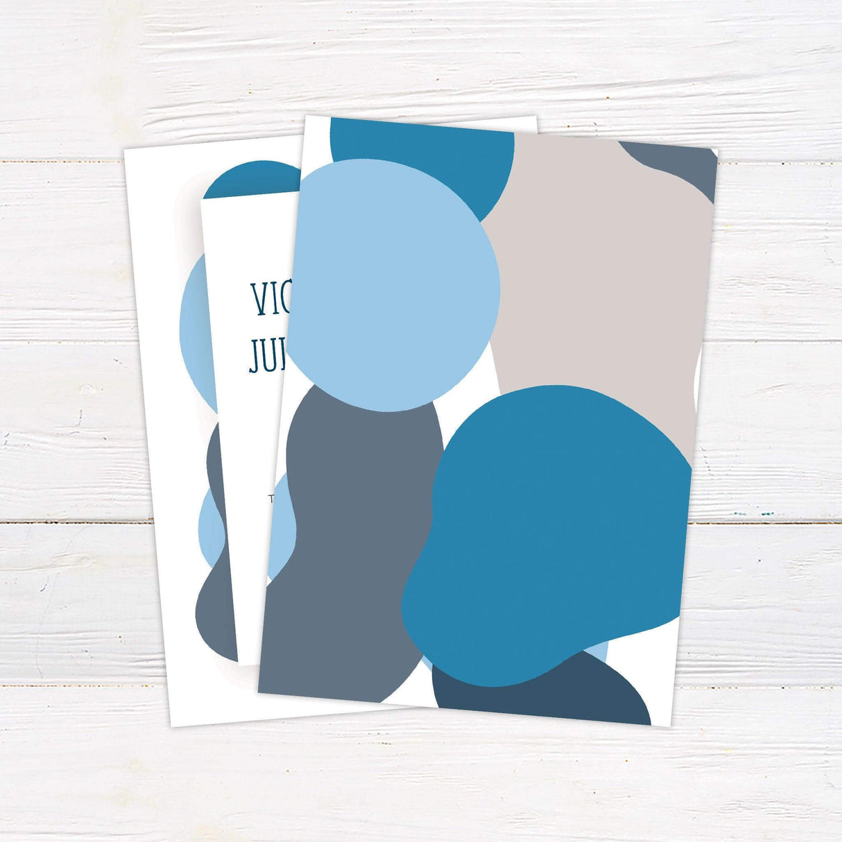 Modern abstract wedding invitation with layered navy and blue organic shapes, retro typography, and minimalist white layout. back