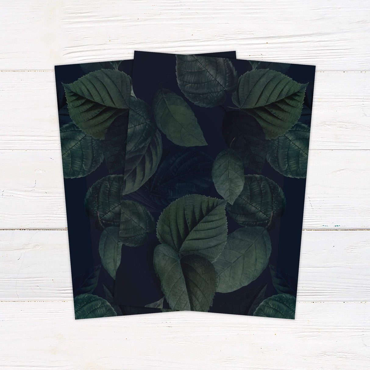 Elegant wedding invitation featuring dark green watercolor leaves with modern script text for a botanical evening wedding back