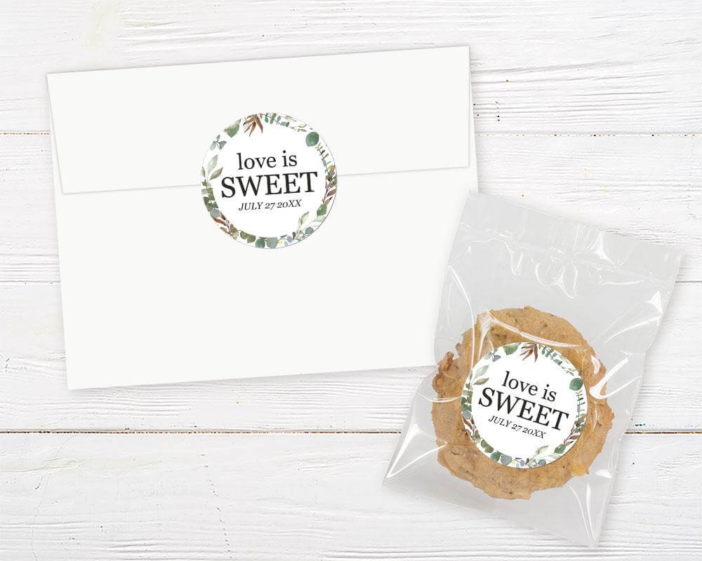 Invitation envelope and cookie favor with 'Love is Sweet' label featuring botanical design for bridal shower theme.