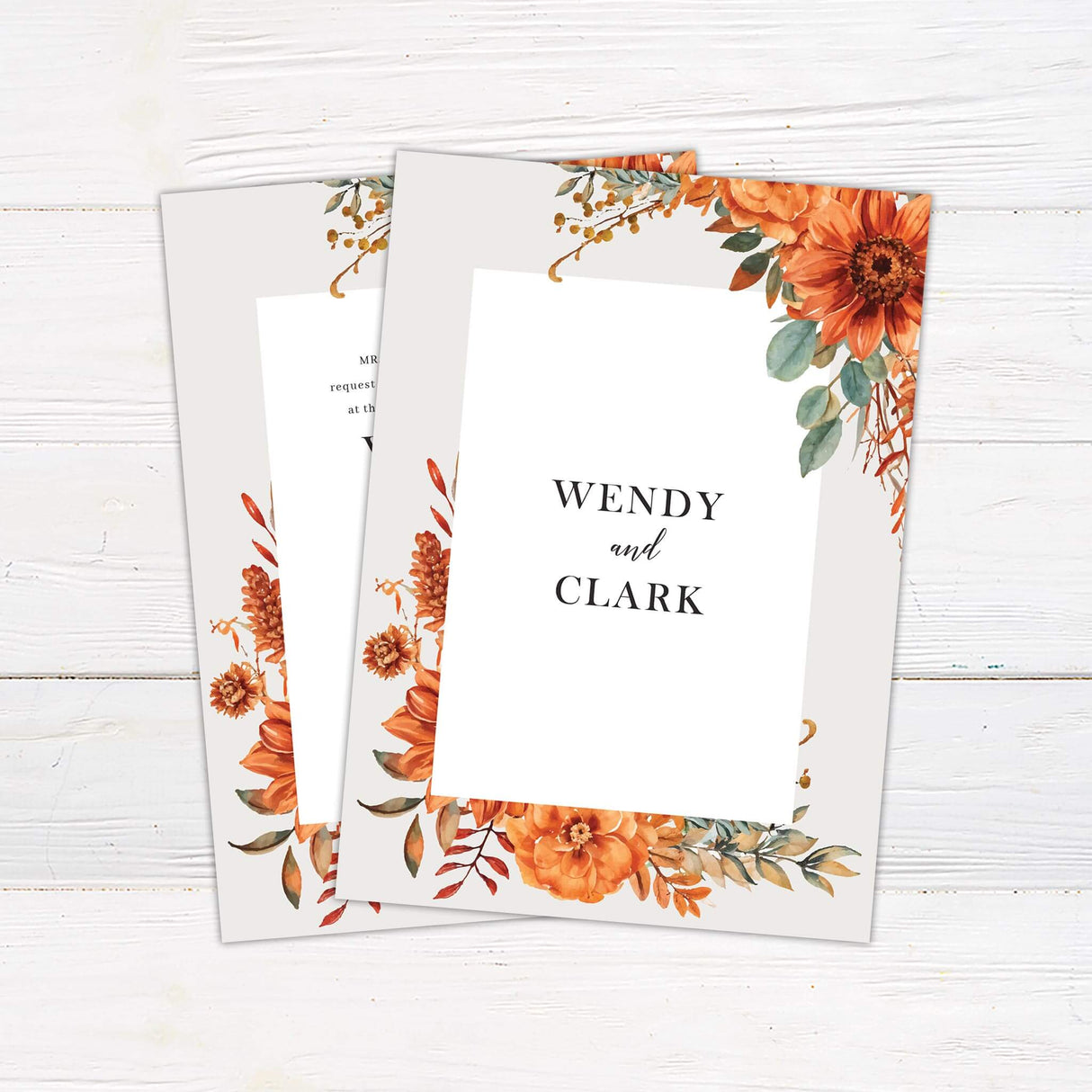 A wedding invitation with a neutral background features vibrant watercolor florals in warm autumn tones of orange, gold, and green framing the design. The text is centered within a white rectangular box, using a mix of serif and script fonts for a classic and elegant feel. Event details, including the date, time, and venue, are clearly displayed in a structured layout. This design exudes warmth and sophistication, perfect for a fall or rustic-themed wedding celebration. Back