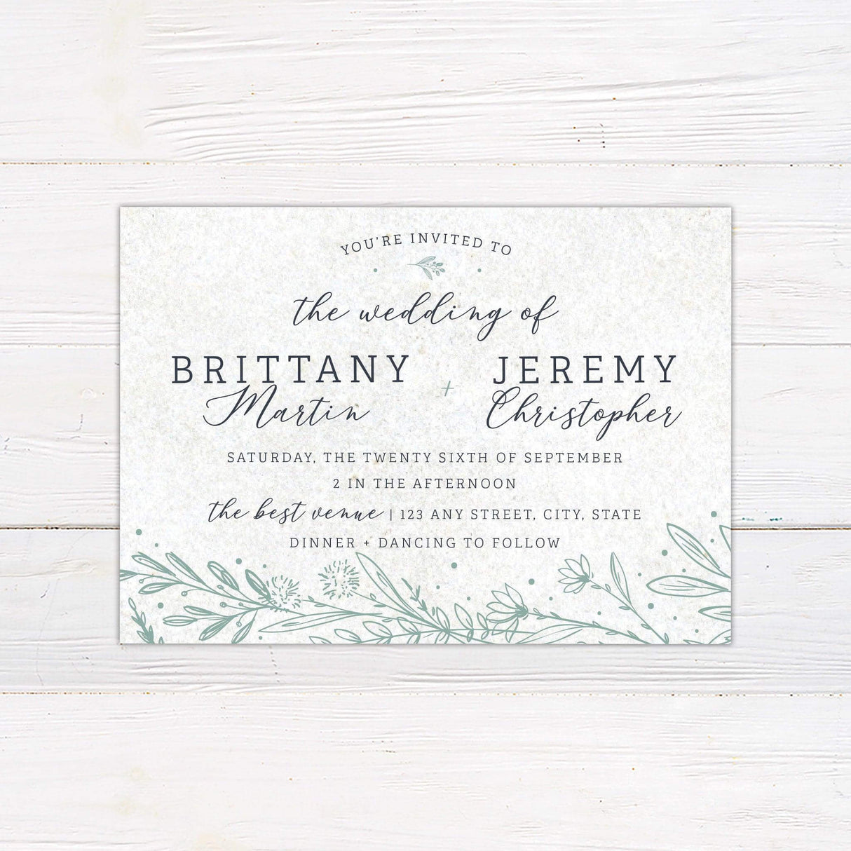Elegant wedding invitation with green botanical accents and script and serif typography, ideal for garden, outdoor, or nature-themed weddings