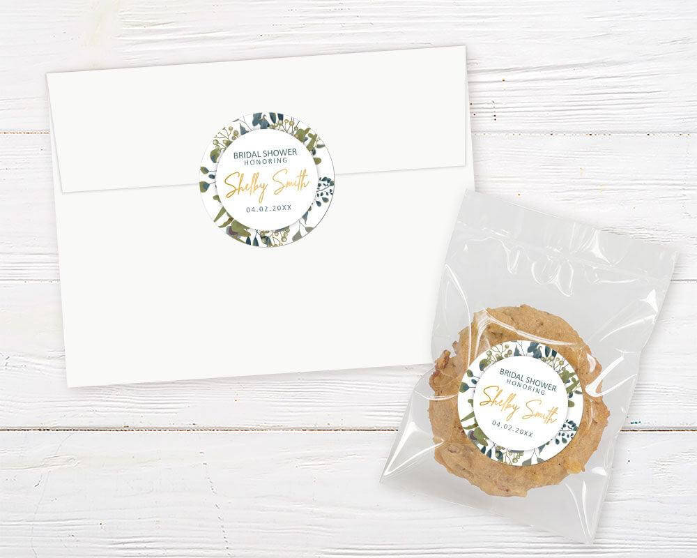 A Botanical Leaves sticker with a circular center and green leaf design. The invitation features modern typography and natural greenery accents.
