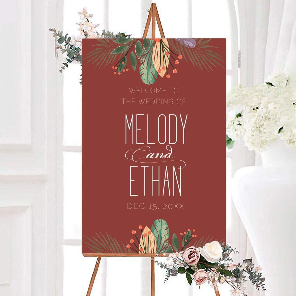 Personalized bright boho wedding welcome sign featuring tropical leaves, berries, and colorful botanical accents. Modern lettering displays the couple’s names and wedding date on a rich background.
