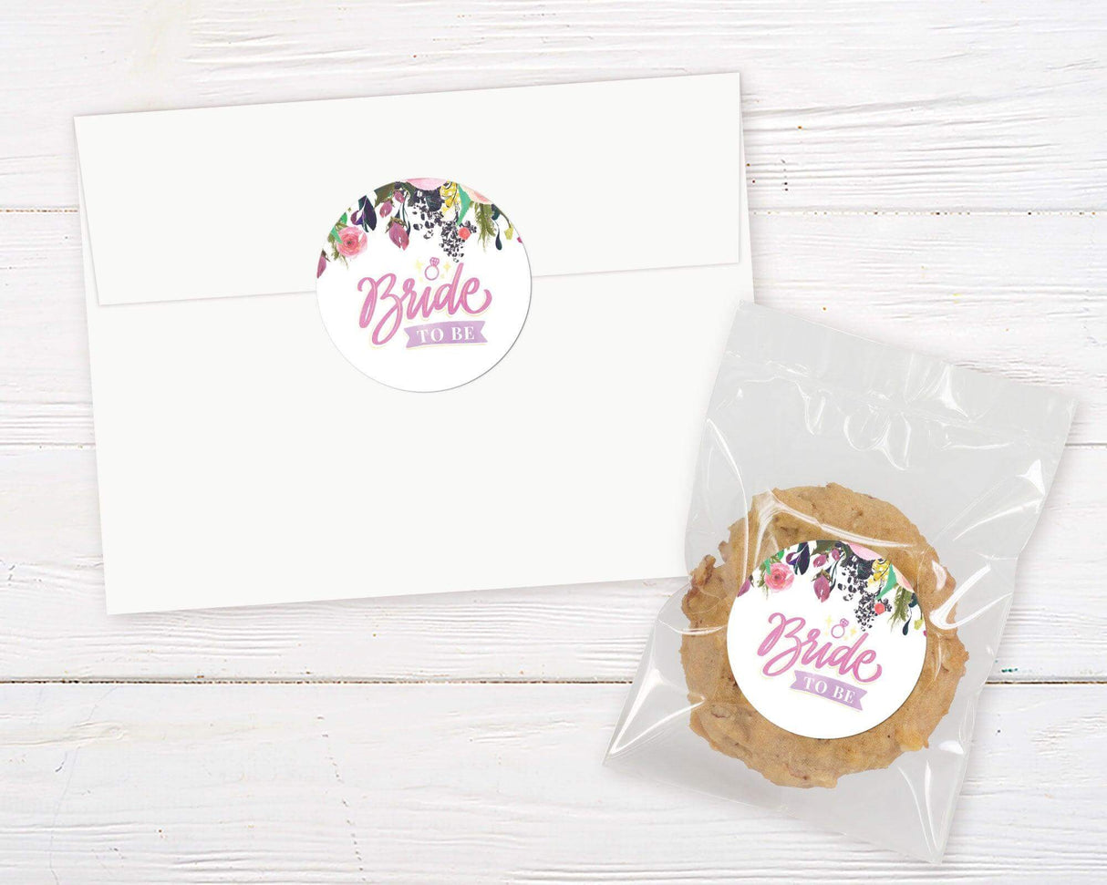 A bright floral bridal shower invitation sticker with colorful painted flowers at the top. The design features soft script text on a white background.