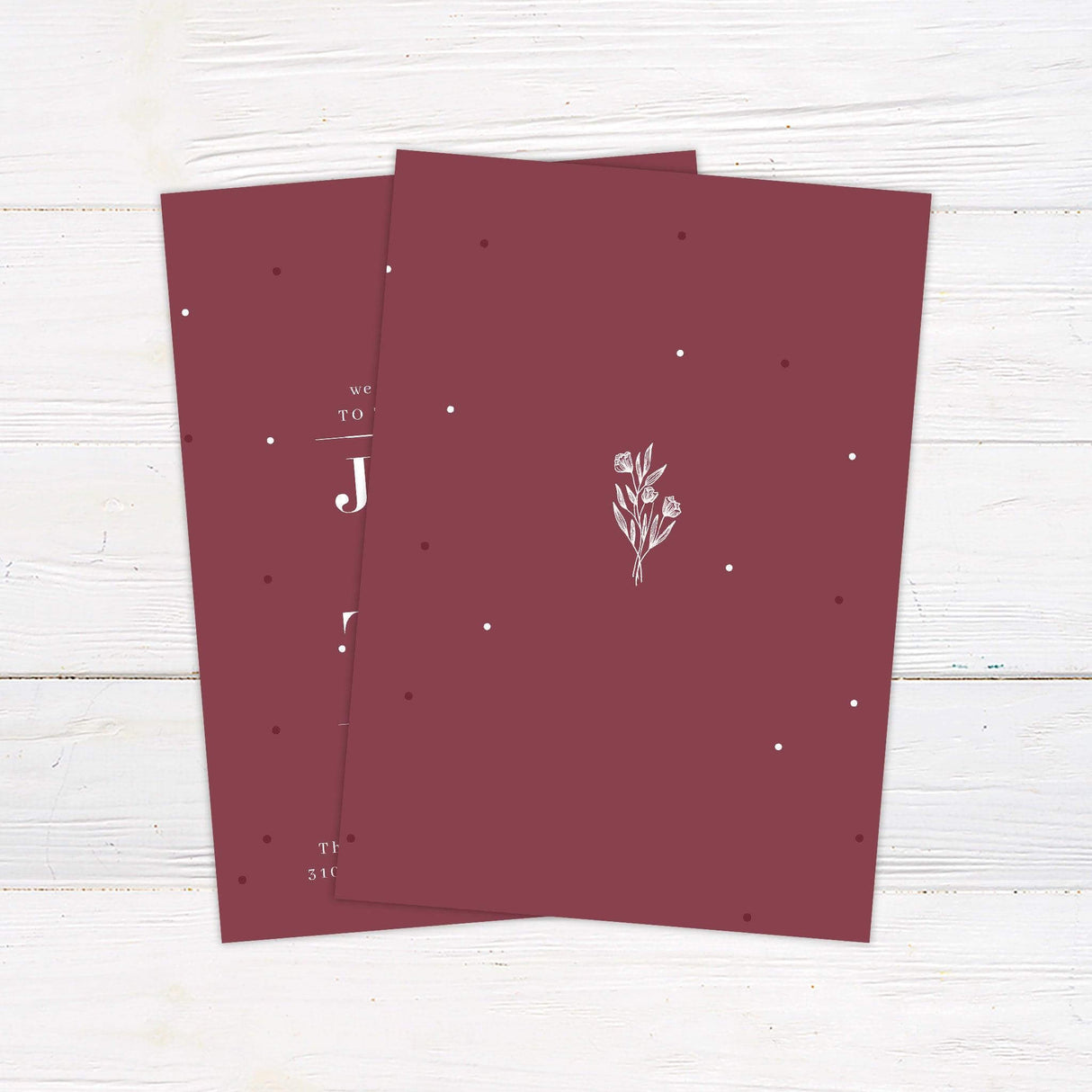 Minimalist burgundy botanical wedding invitation with elegant serif typography and floral illustration, perfect for modern or formal weddings.