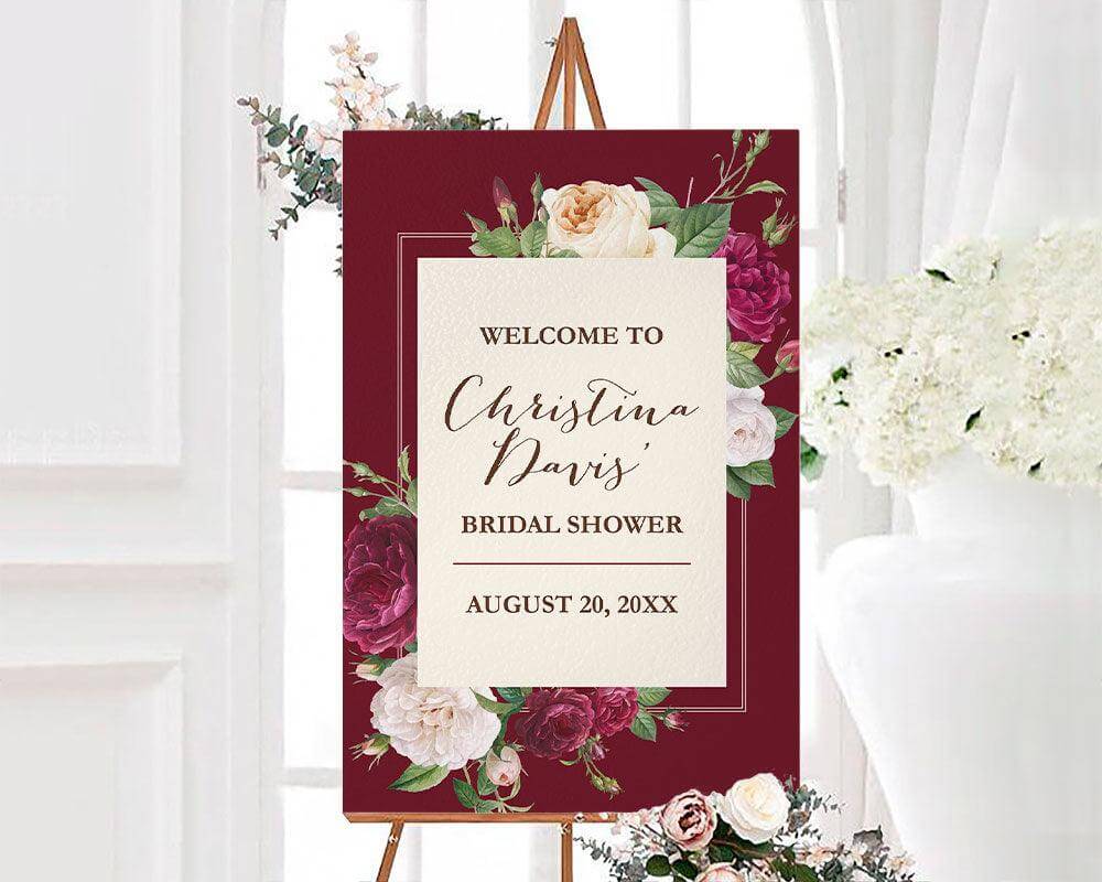 A burgundy rose floral bridal shower sign with roses and elegant script text. The design features deep red and blush flowers on a dark background.