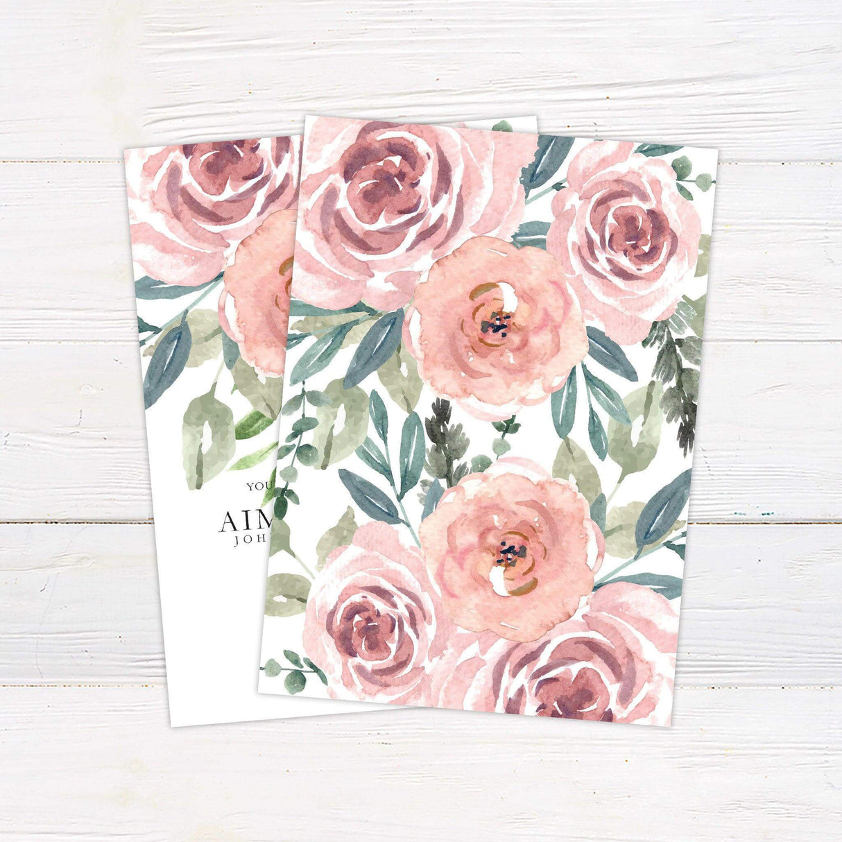 Wedding invitation with watercolor blush roses cascading from the top, featuring elegant serif and script fonts on a white background. - back