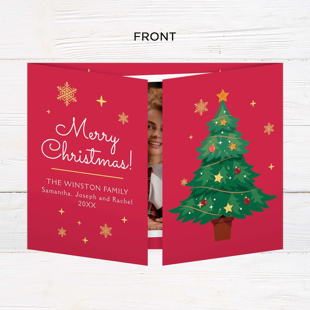 Gatefold Christmas card with a festive red background, decorated with gold snowflakes, a large illustrated Christmas tree, and photo frames with family holiday moments. The design includes a cheerful “Merry Christmas” message and space for personalized names and year details. - front.