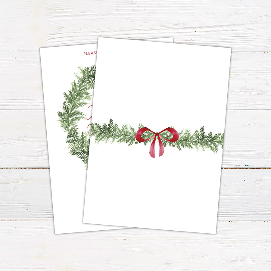 Double-sided Christmas bridal shower invitation featuring a watercolor evergreen wreath, elegant red script lettering, and a festive ribbon bow. The coordinating back design features horizontal evergreen greenery with a matching red bow on a white background. - back.
