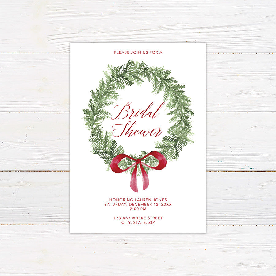 Double-sided Christmas bridal shower invitation featuring a watercolor evergreen wreath, elegant red script lettering, and a festive ribbon bow. The coordinating back design features horizontal evergreen greenery with a matching red bow on a white background.
