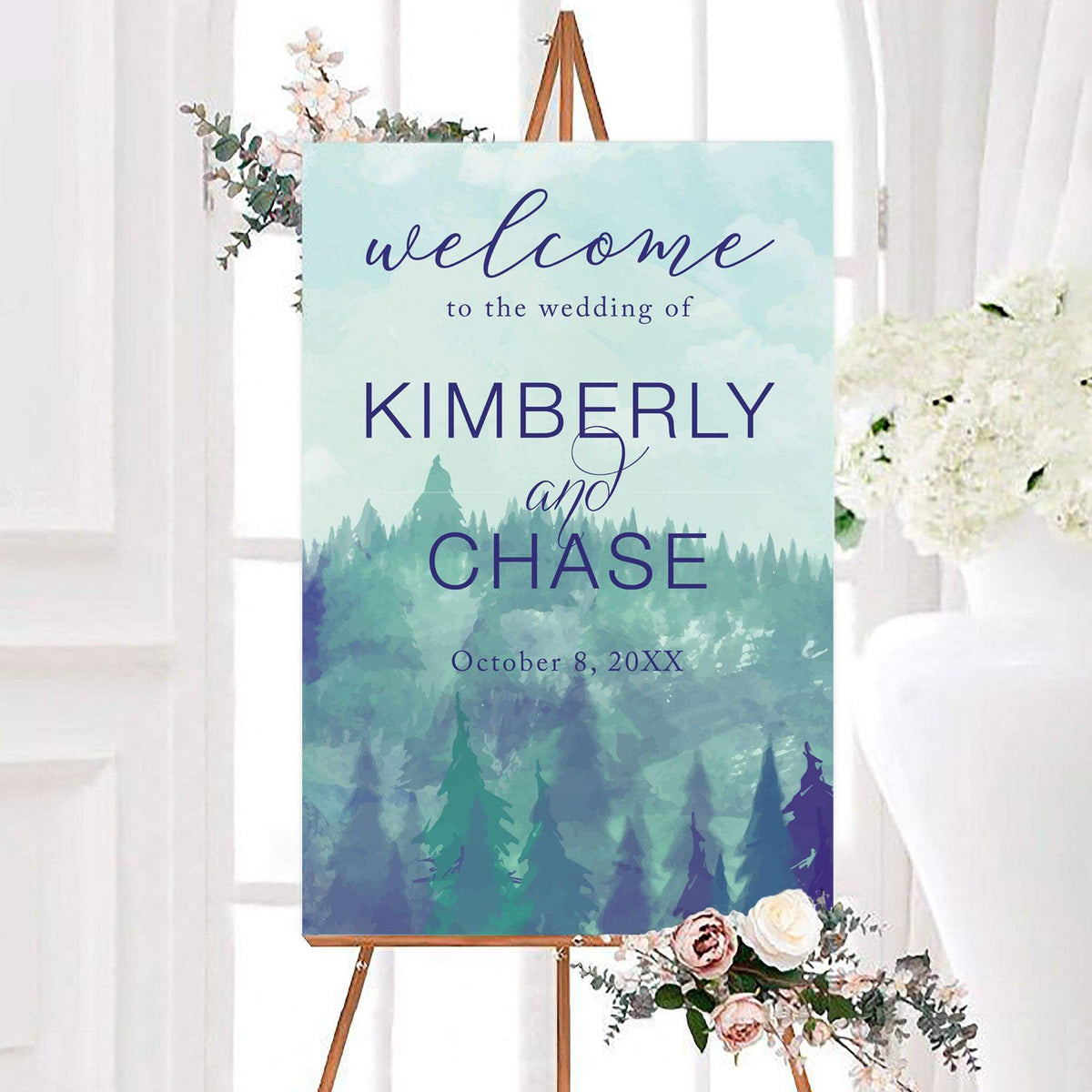 Personalized cloudy valley watercolor forest wedding welcome sign featuring misty evergreen trees, a soft cloudy sky, and elegant blue lettering. The mountain woodland wedding sign includes customizable couple's names and wedding date over a peaceful layered forest landscape.