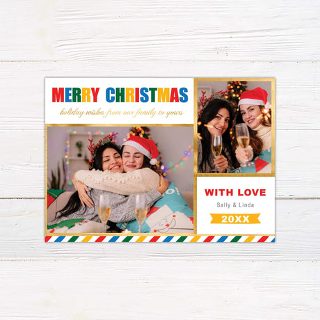 Colorful photo Christmas card with festive gold borders, rainbow "Merry Christmas" lettering, and customizable text featuring two women hugging and celebrating.