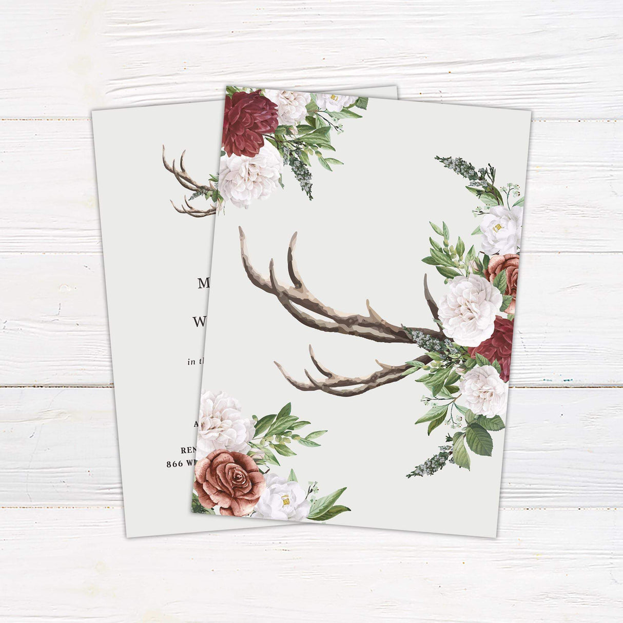 Wedding invitation with watercolor antlers, burgundy and white roses, greenery, and serif typography on a light cream background - back