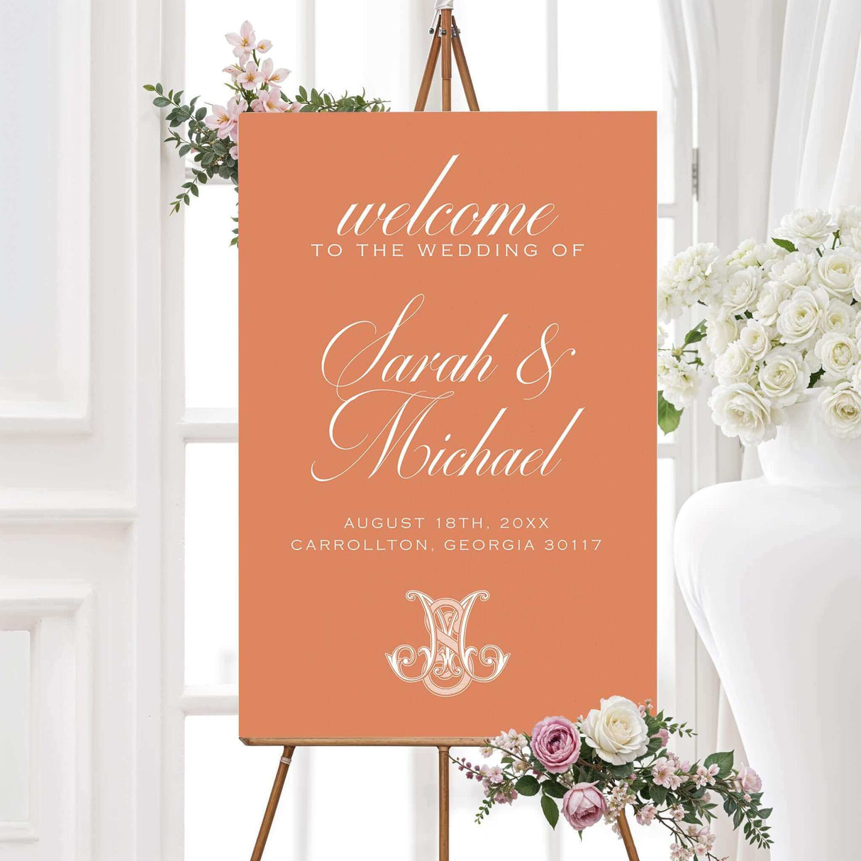 Terracotta wedding welcome sign with ornate monogram and white serif text