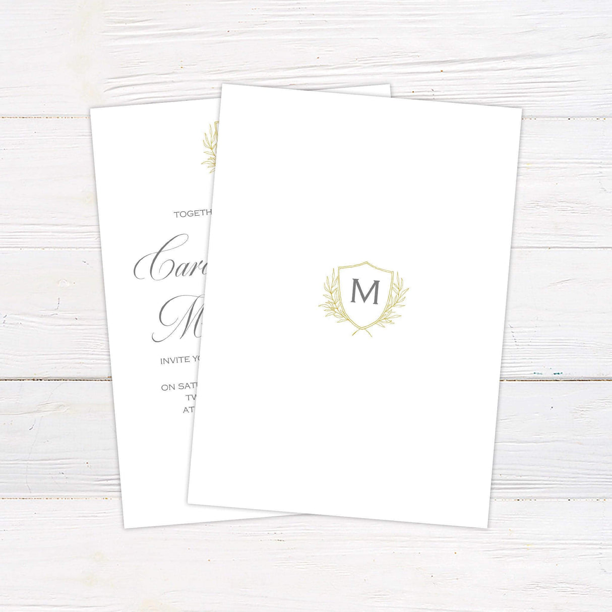 Wedding invitation with delicate monogram crest, gold shield and laurel, script and serif fonts on a soft ivory background - back