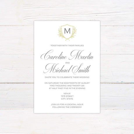 Wedding invitation with delicate monogram crest, gold shield and laurel, script and serif fonts on a soft ivory background