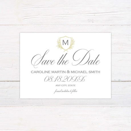 Elegant Delicate Shield Invitation with gold monogram crest and laurel details on ivory background for weddings.