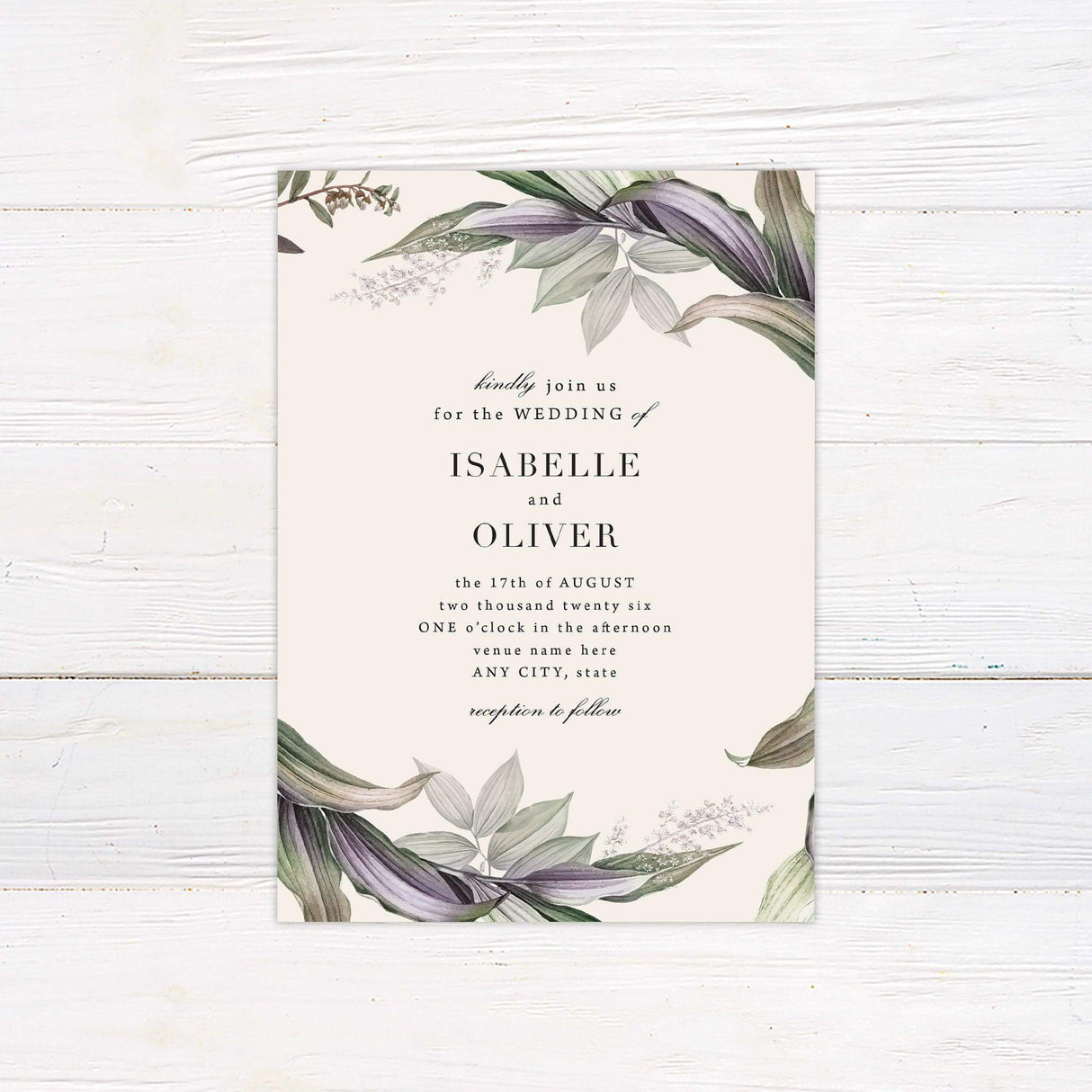 Elegant wedding invitation with watercolor botanical foliage in green and violet shades, featuring serif and script text on a cream background.
