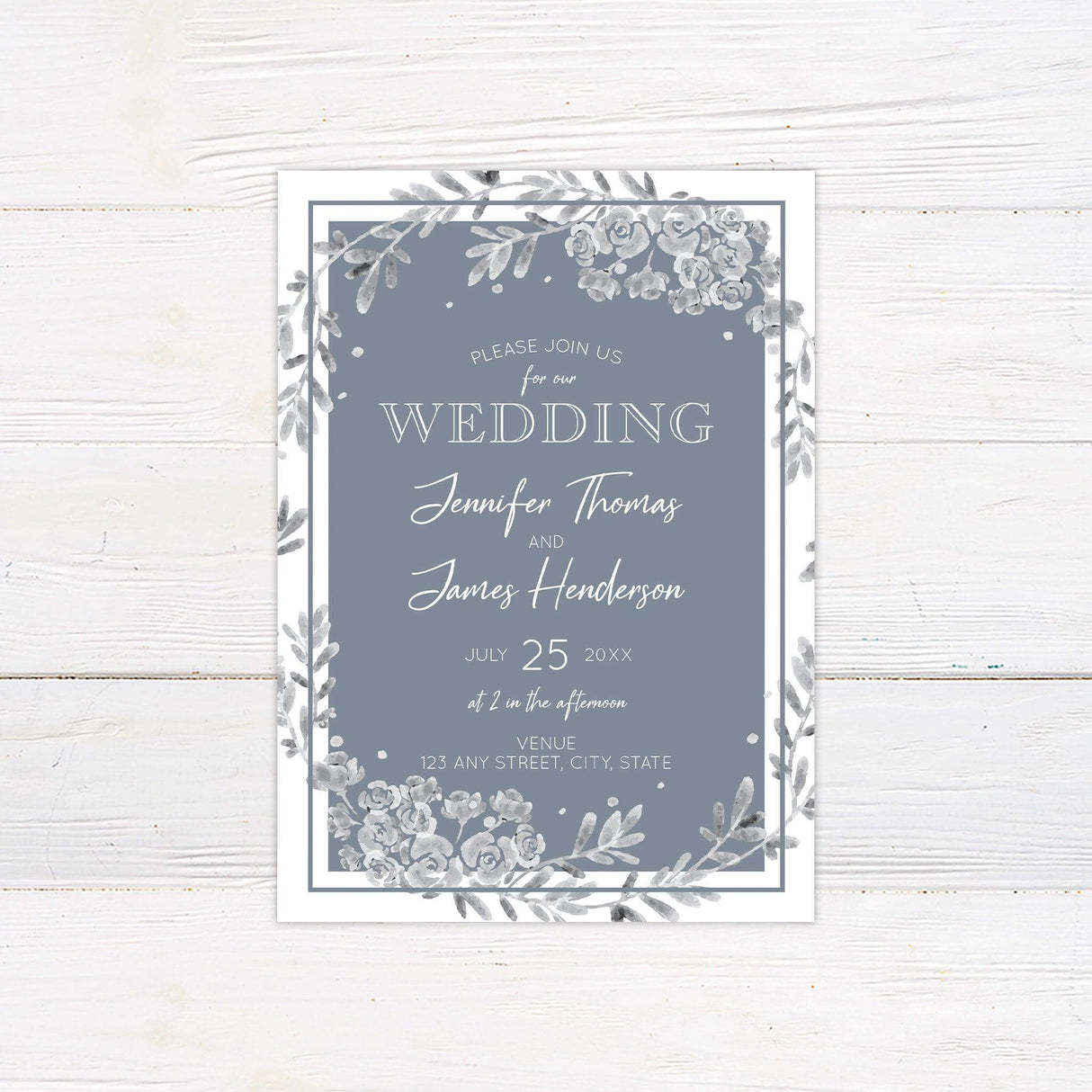 Dusty blue wedding invitation with gray watercolor floral wreath, elegant script typography, and slate blue background