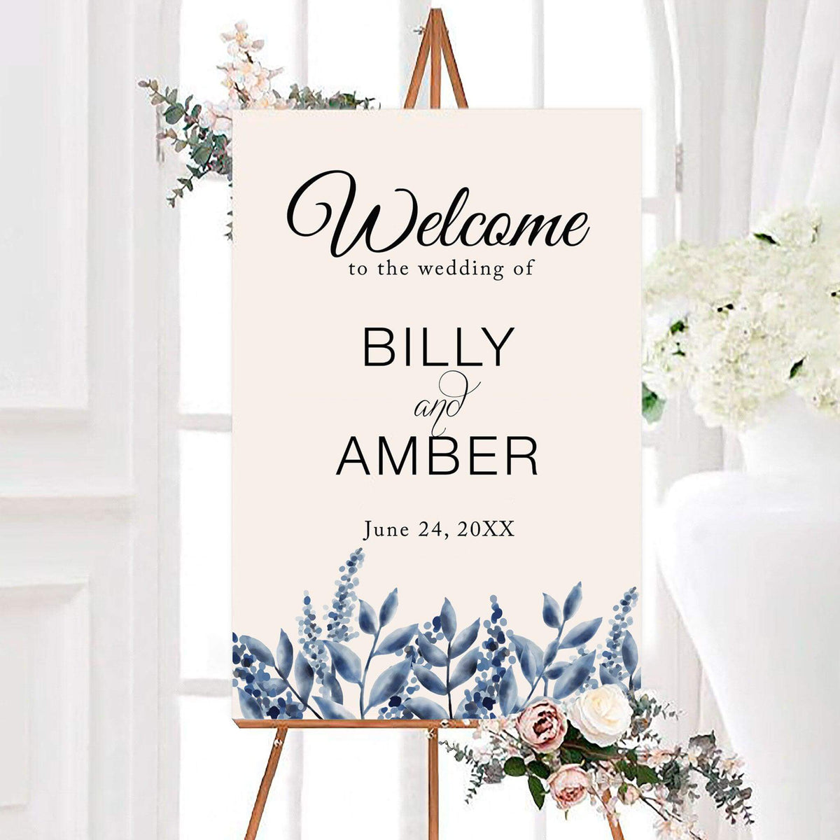 Elegant blue watercolor leaves wedding welcome sign featuring watercolor botanical leaves and delicate floral sprigs along the bottom. The sign is personalized with the couple’s names and wedding date.