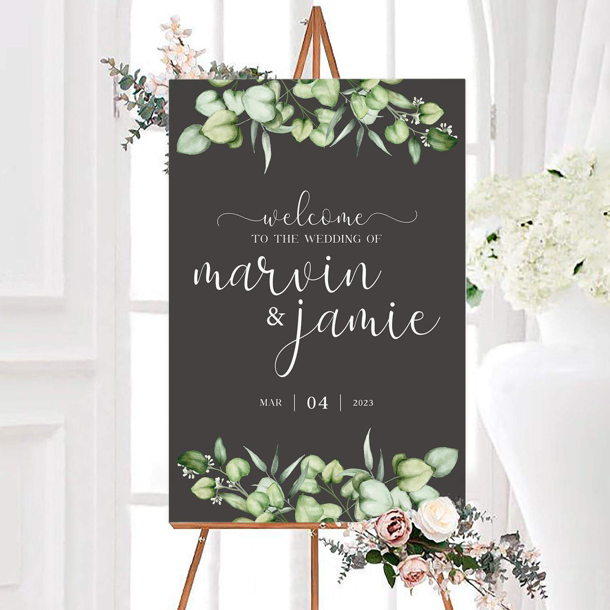 Personalized elegant eucalyptus greenery wedding welcome sign featuring watercolor eucalyptus greenery against a dark charcoal background. Elegant white script displays the couple’s names with coordinating wedding details and date.
