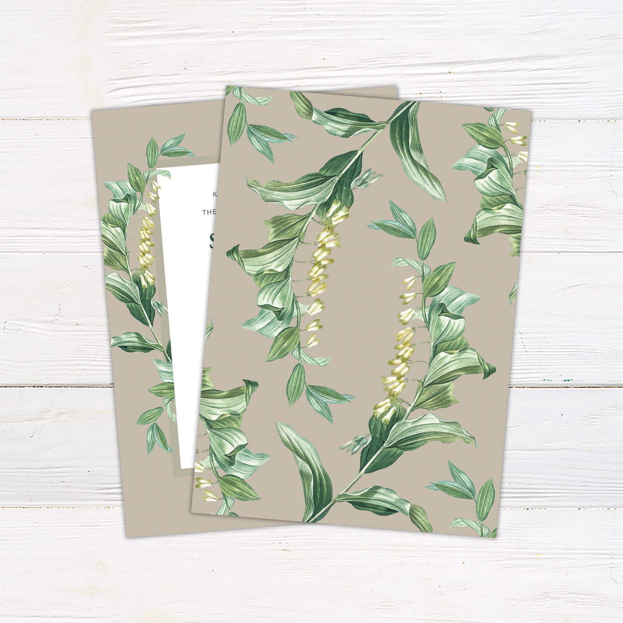 Elegant wedding invitation with green watercolor botanical border, taupe background, serif and script text, and minimalist layout - back