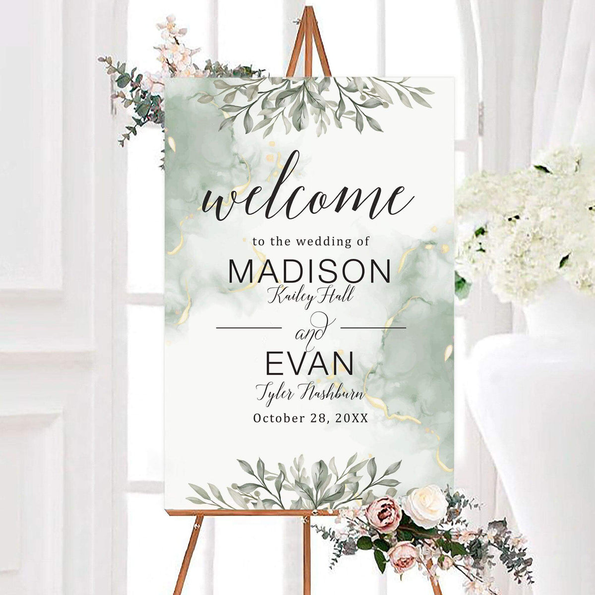 Elegant greenery wedding welcome sign featuring leafy branches, soft marbled accents, and personalized couple names. Elegant script and modern lettering display the wedding date in the center.