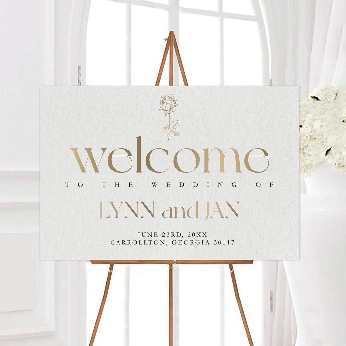 Elegant initials wedding welcome sign with oversized typography and a delicate single rose illustration. The sign features custom couple names, wedding date, and location on a softly textured background.