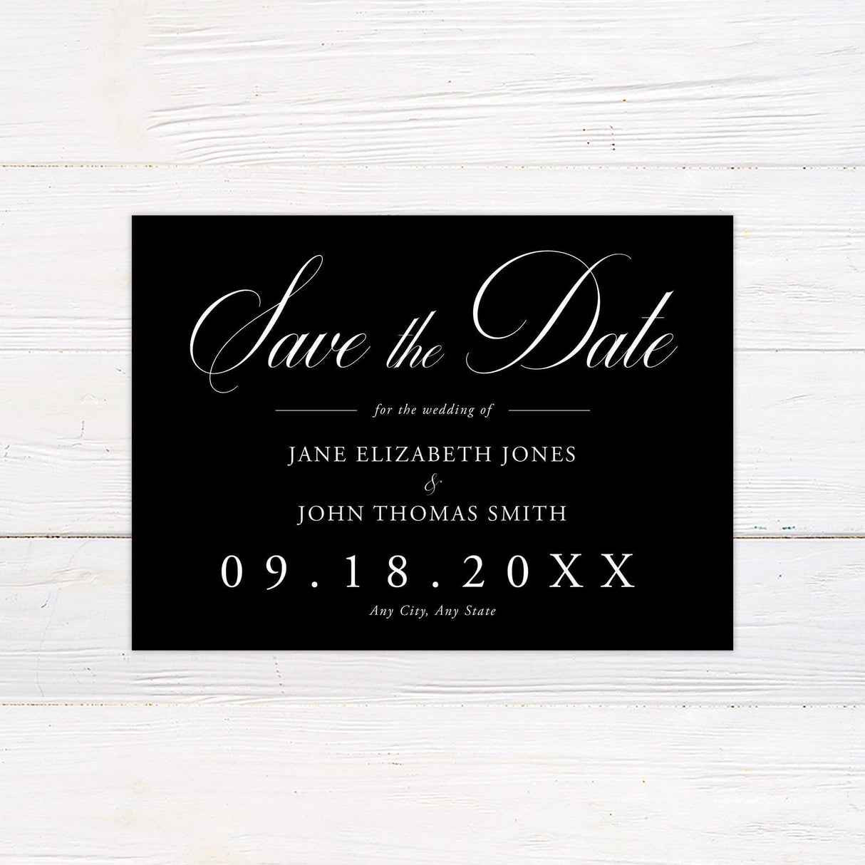 A save-the-date card with a dark background features elegant white script and serif typography. "Save the Date" is prominently displayed in large, flowing script, with the wedding date and location arranged in a structured, sophisticated layout. The design exudes timeless elegance, making it perfect for a formal, classic, or modern wedding announcement.