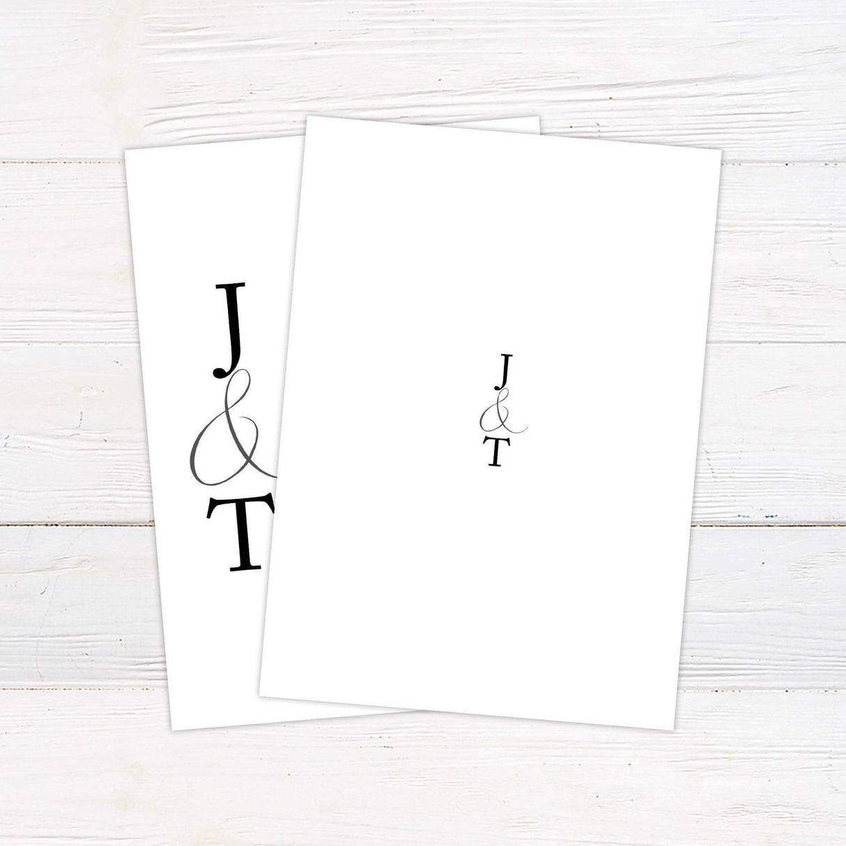 Minimalist wedding invitation with black serif typography and monogram initials on a clean white background - back