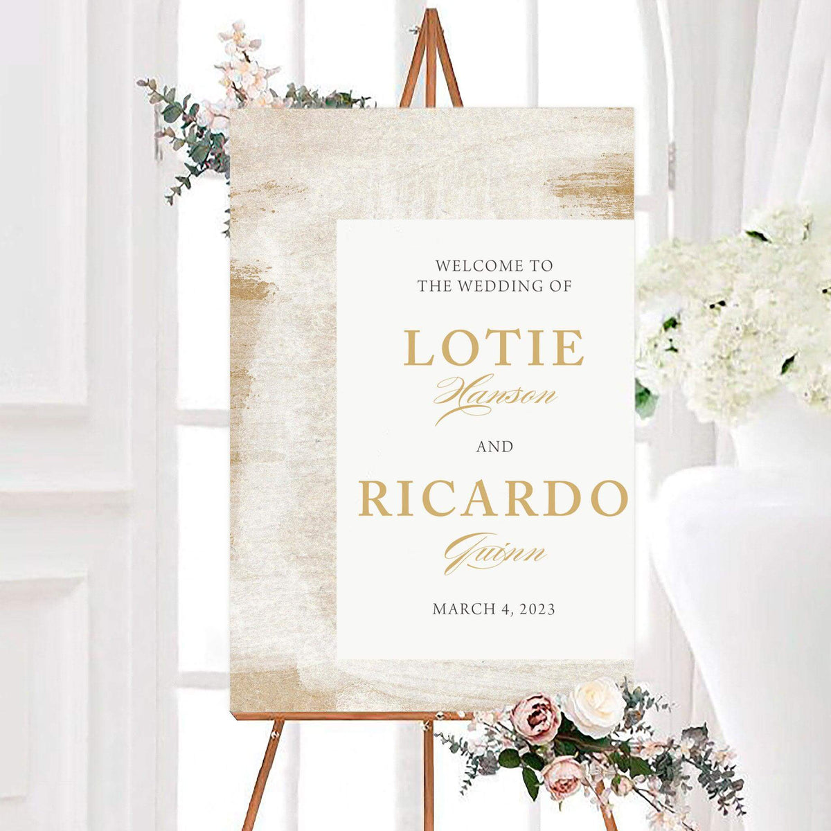 Elegant personalized etched sand wedding welcome sign with a textured sand-inspired background and white center panel. The design features the couple’s names and wedding date in classic and script typography.