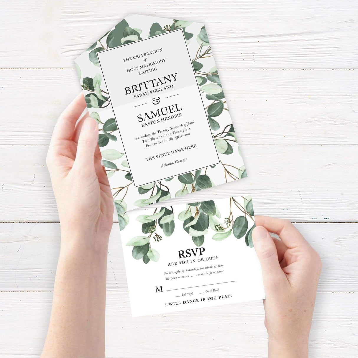 Elegant wedding invitation with a greenery design featuring eucalyptus leaves and gold accents. Folded design includes event details, RSVP section, and additional information. Classic black and white typography on high-quality cardstock. Perfect for a modern or nature-inspired wedding.